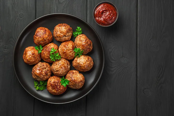meatballs with basil and tomato sauce on a black background top view, copy space