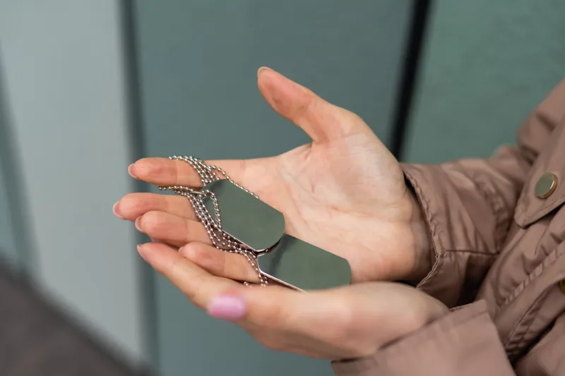 woman holding in hand military token