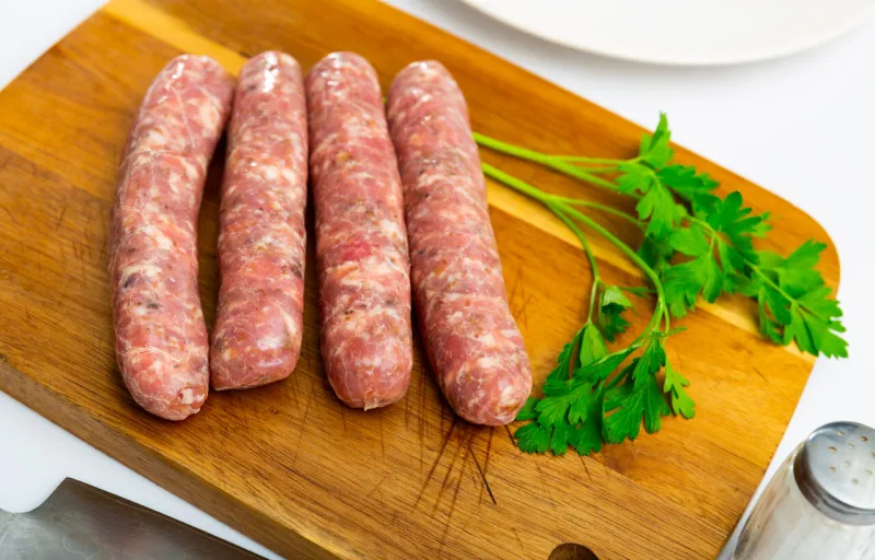 raw sausages butifarra prepared for barbecue on white plate traditional catalan meat products