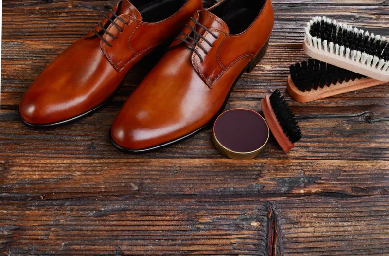 men leather shoes and care products on wood