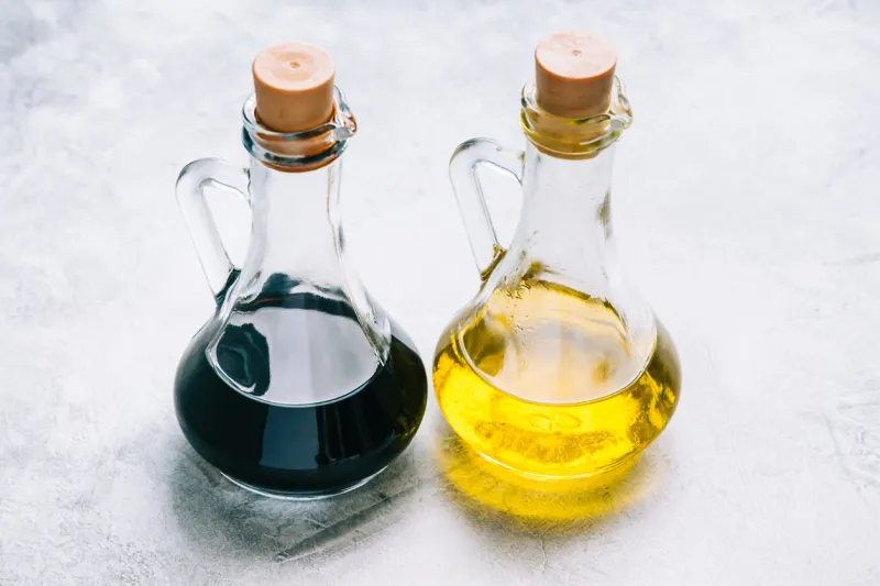 olive oil and balsamic vinegar in bottles on the table salad sauce