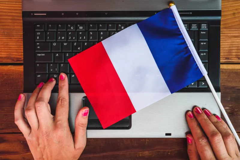 woman hands and flag of france on computer, laptop keyboard