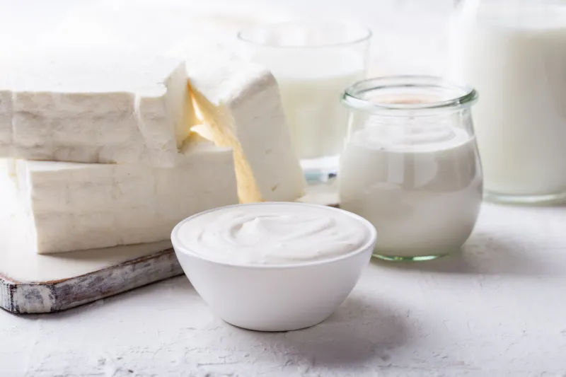 homemade sour cream and fresh cottage cheese on white wooden board, homemade organic dairy products on rustic table