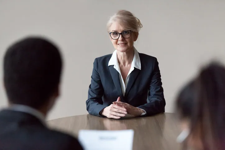 smiling middle aged senior female job applicant listening to hr questions making first impression at interview, recruiters interviewing older mature candidate, recruitment, age and employment concept