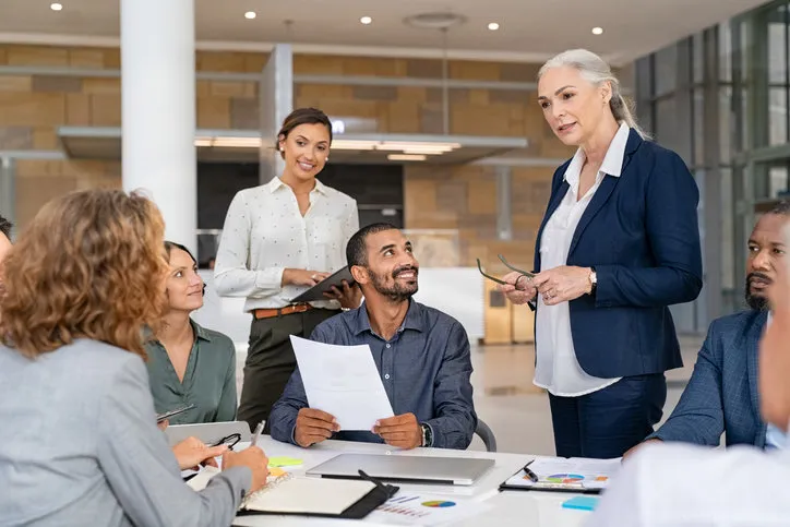 group of mixed race business people discussing work in conference room senior business manager guiding employees in meeting group of businessman and businesswoman working together while brainstorming and sharing new ideas and strategy