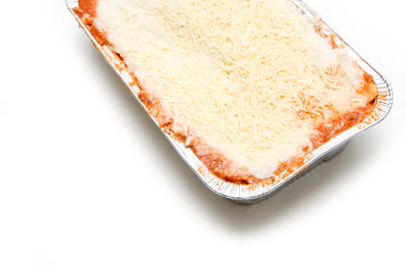 the semifinished lasagne in the aluminium tub isolated on a white background the fast ready to cook meal