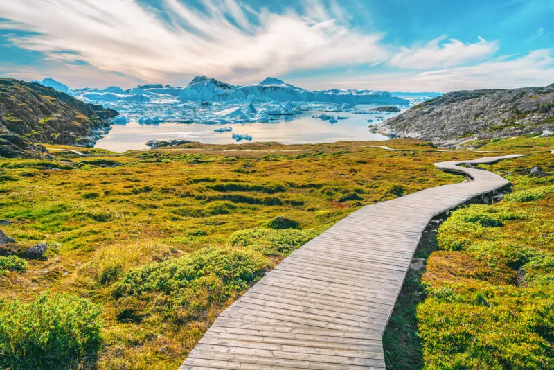 hiking trail path in greenland arctic nature landscape with icebergs in ilulissat icefjord photo of scenery ice and iceberg in greenland in summer