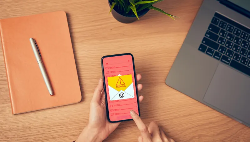 concept of cyber crime, hand holding smartphone and show malware screen that comes with email, hack password from bank accounts and personal data