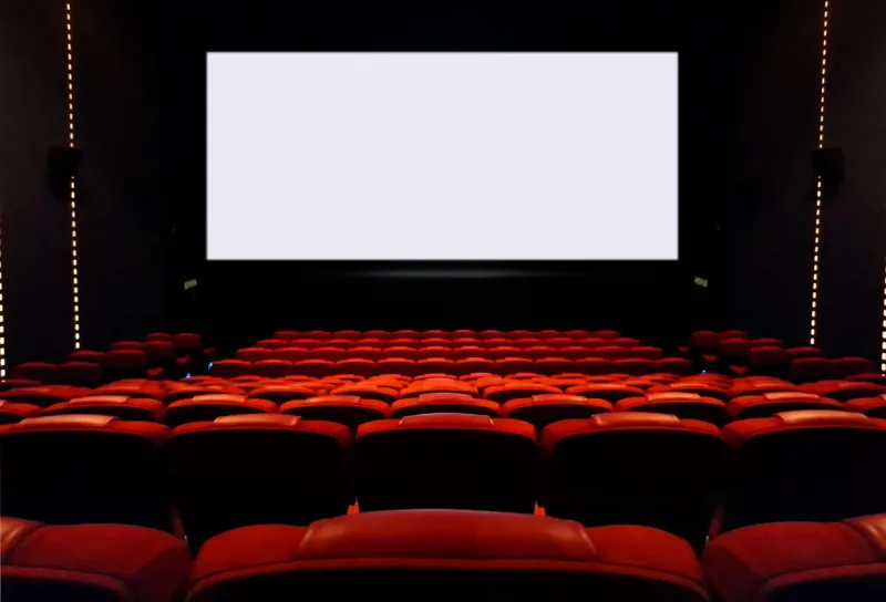 interior view of empty movie seat and blank cinema screen