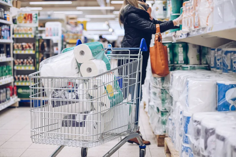 woman shopping at supermarket choosing toilet paper the most important thing is to make a stock of toilet paper during pandemic