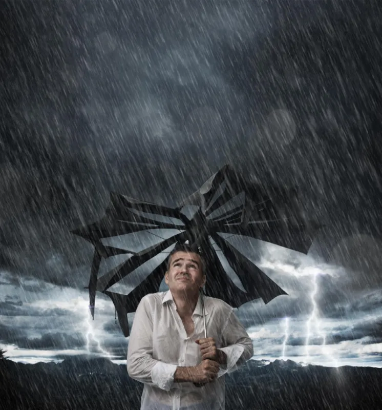 disappointed man with broken umbrella after an unexpected storm, he is wet and dripping