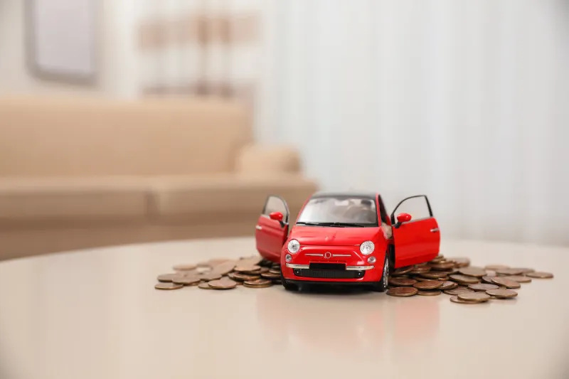 miniature automobile model and money on table indoors car buying