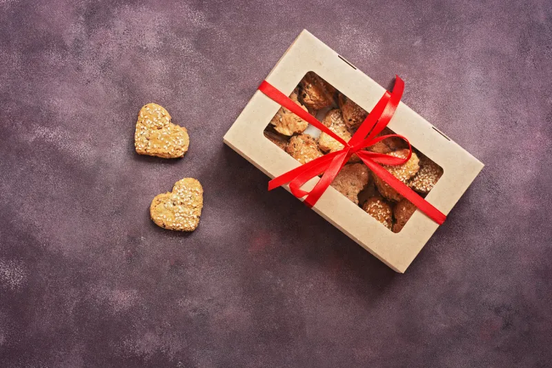 cookies heart in a box with a red ribbon on a dark grand background valentine's day view from above, flat lay, copy space