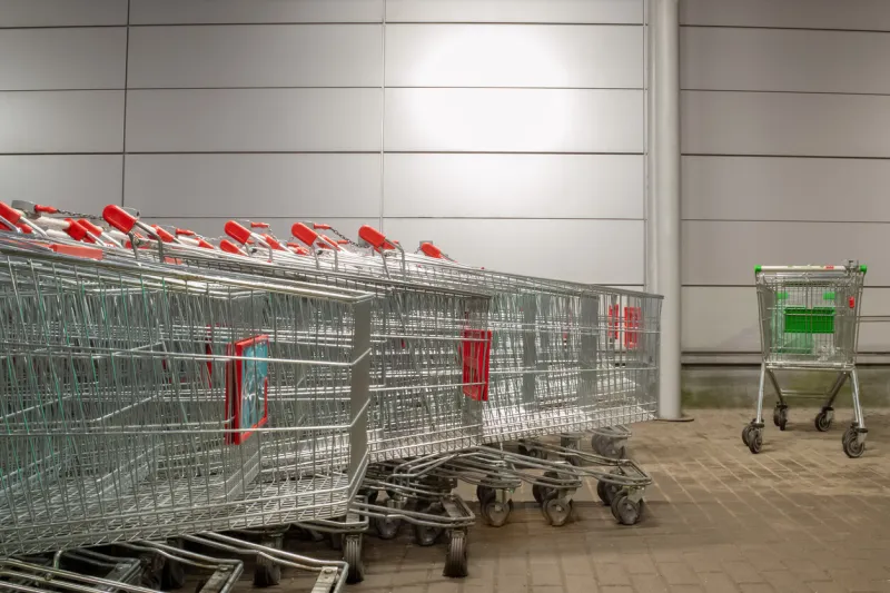 row of supermarket carts on the street, next to the store evening