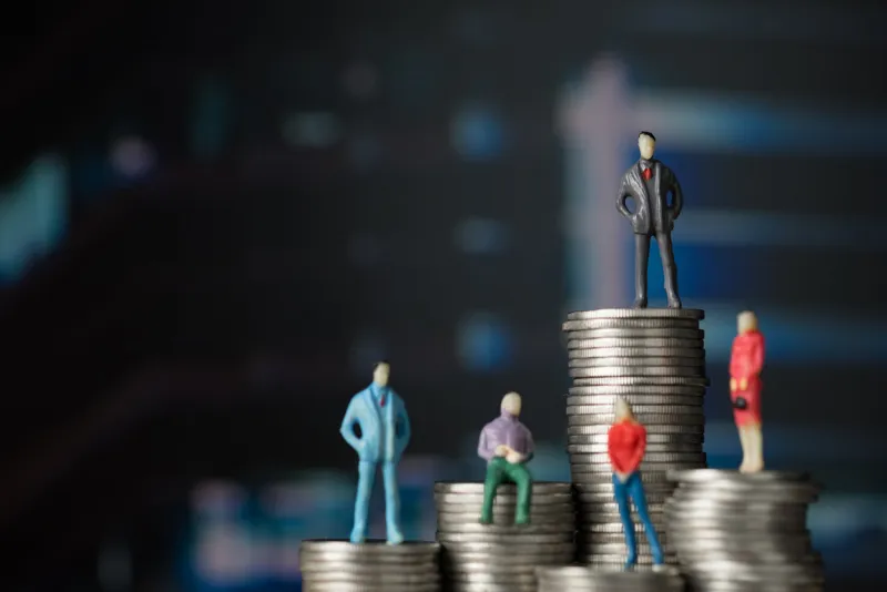 figure miniature businessman of small people investor and office worker secretary standing on stack of coin, with modern city background for money and financial business success concept shallow focus