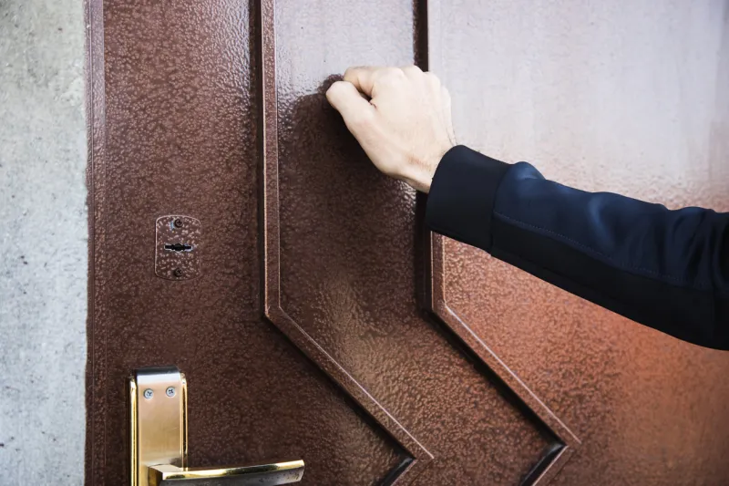 a man knocks on an iron door