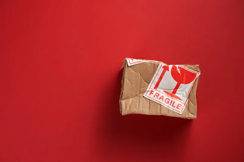 damaged cardboard box isolated on red
