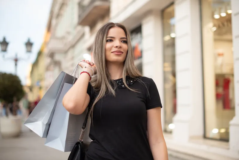 portrait of a happy woman enjoying shopping in the city stock photo