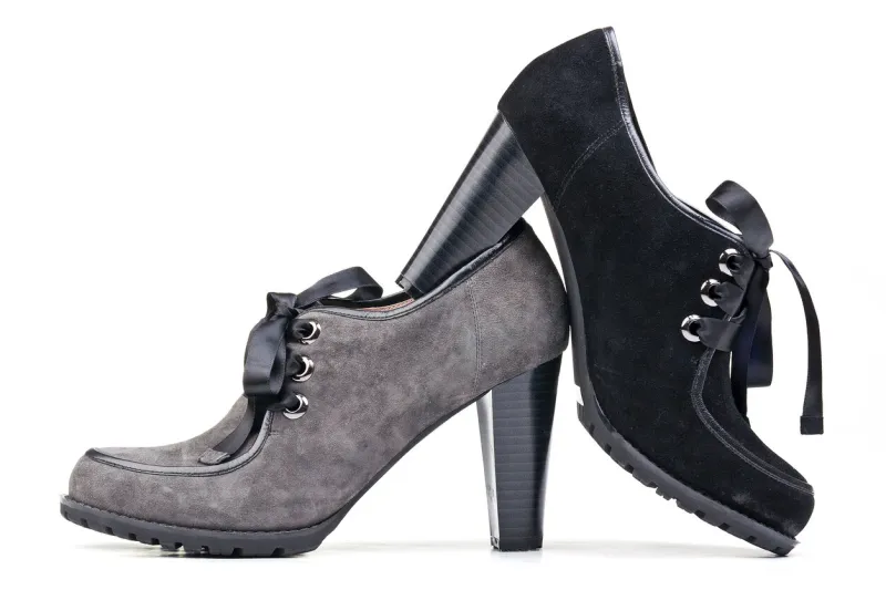 two elegant suede female shoes over white background