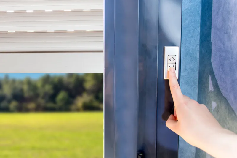 woman lifting electric shutters in house
