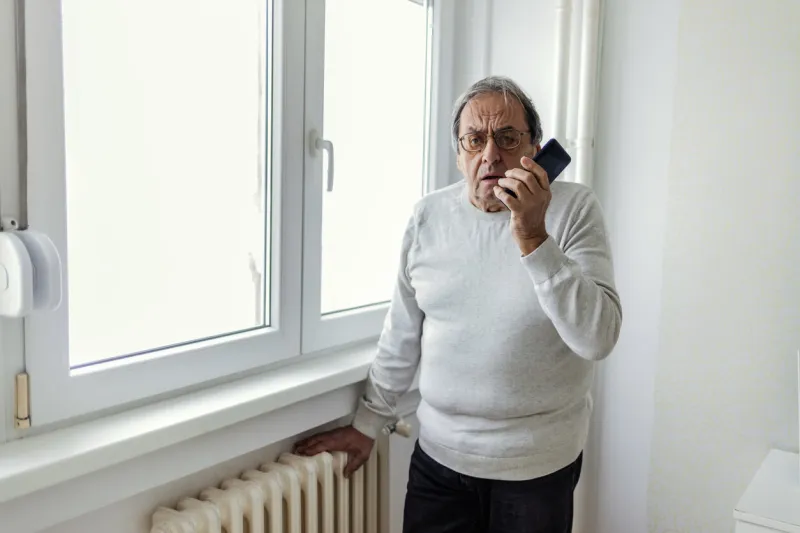 man suffering cold at home and problem with house heating, calling repair service for help senior man feeling cold at home with home heating trouble copy space