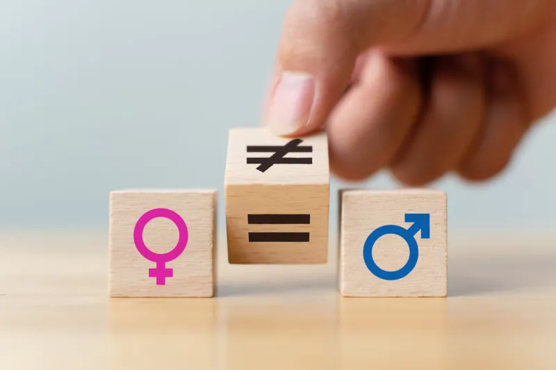 concepts of gender equality hand flip wooden cube with symbol unequal change to equal sign