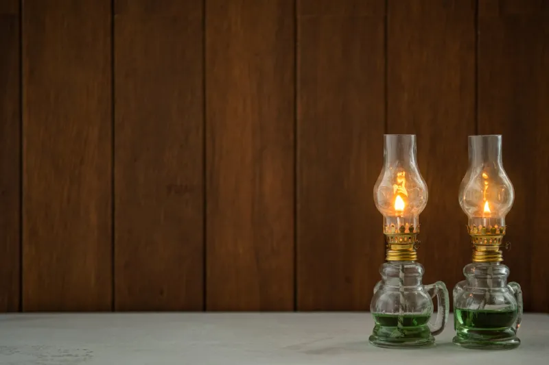 there is a vintage oil lamp on the table the background is a wooden board