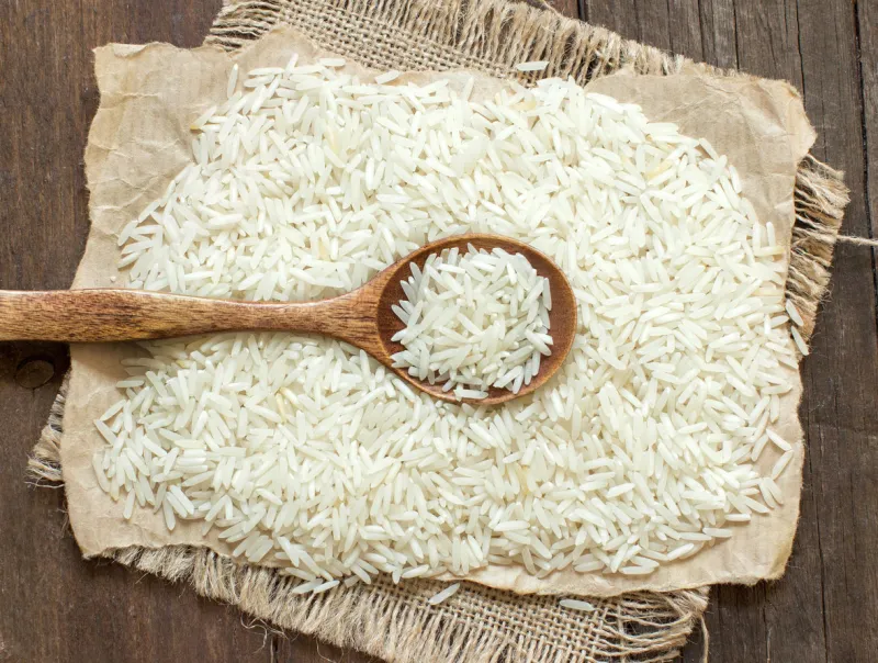 basmati rice with a spoon on an dark wood