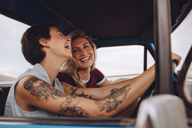 happy young women laughing and enjoying in car during a road trip to vacation girls having fun on road trip