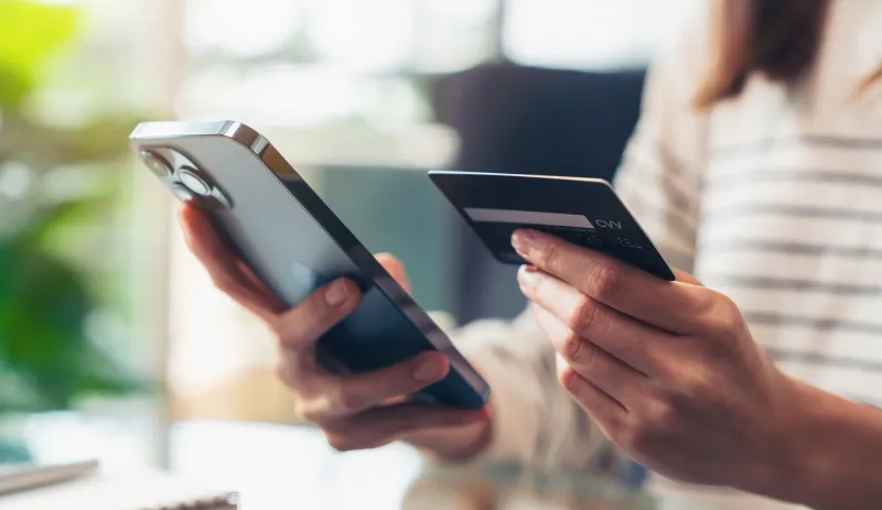 woman hand holding credit cards and using smartphone for shopping online with payment on internet banking