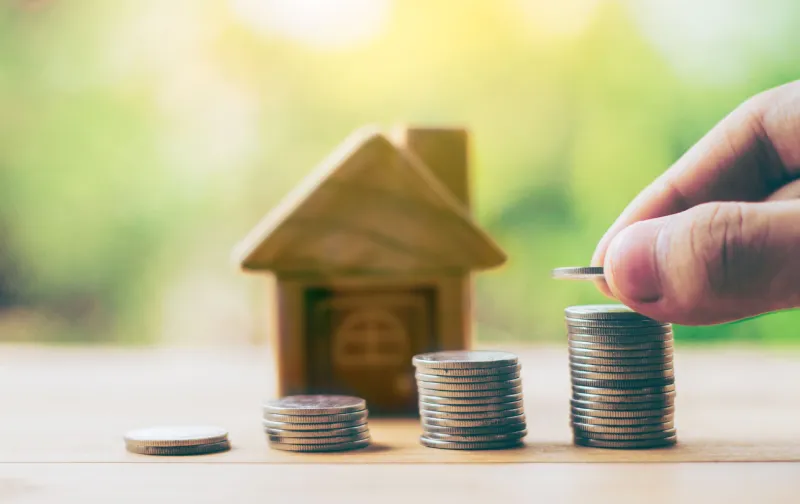 coins and house on the wood is ladder men's hand is putting coins planning savings money of coins to buy a home concept for property ladder, mortgage, real estate, investment saving for a house