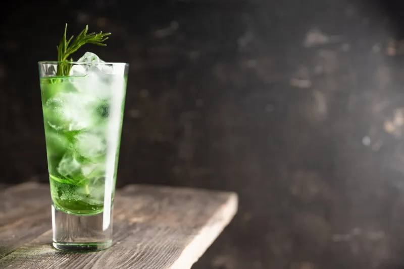 sweet tequila based green cocktail with tarragon and rosemary selective focus shallow depth of field