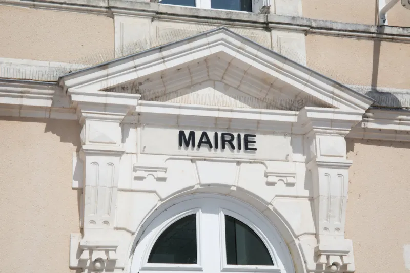 the front of the white town hall of a small town in france,mairie means city or town hall
