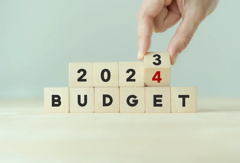 2024 budget planning and allocation concept hand flips wooden cube and changes the inscription budget 2023 to budget 2024 with grey background, copy space use for banner and presentation