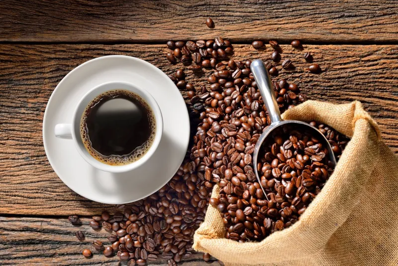 cup of coffee and coffee beans on wooden table