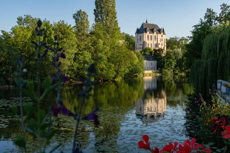 castle raoul with red flower and reflection in water in chateauroux city, france
