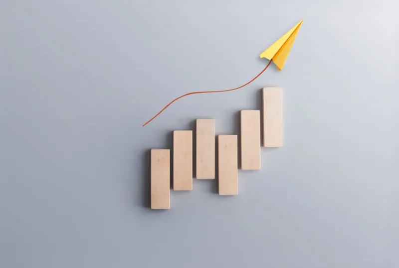 financial success recovery concept, business chart wood blocks with paper airplane moving upwards