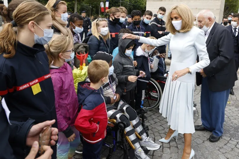 french president's wife brigitte macron (r) meets the crowd at the end of the annual bastille day military parade on the champs-elysees avenue in paris on july 14, 2021 (photo by ludovic marin   pool   afp)