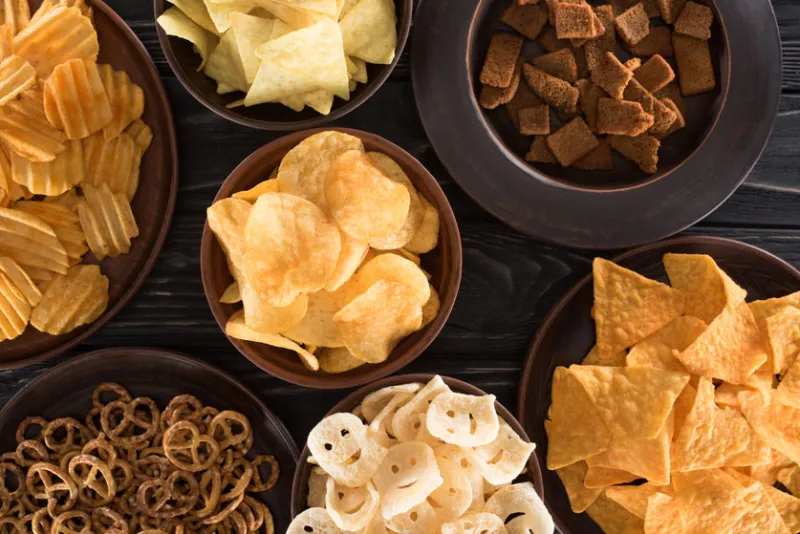 top view of various junk food and snacks on wooden table
