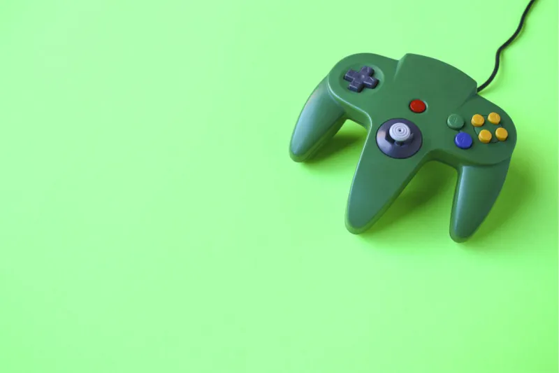 a bright green game controller on a green background with room for copy