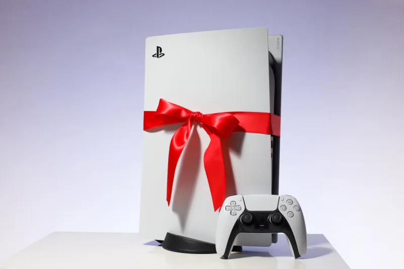 riga, latvia - november 23 2020  sony playstation 5 game console on blue background gift edition with red ribbon