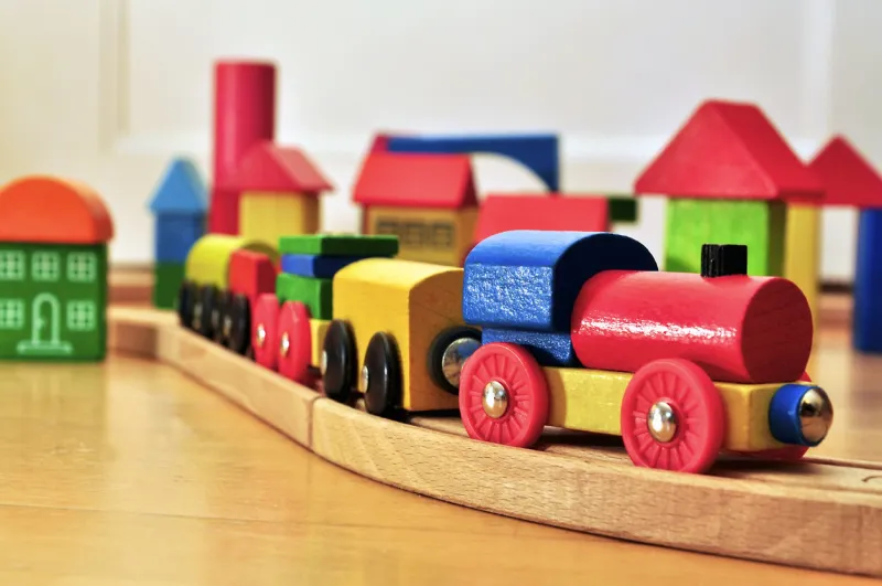 colroful toy train going through a brick town