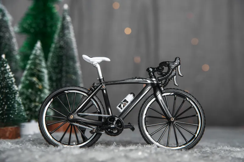 miniature bike on background of christmas trees and snow winter cycling
