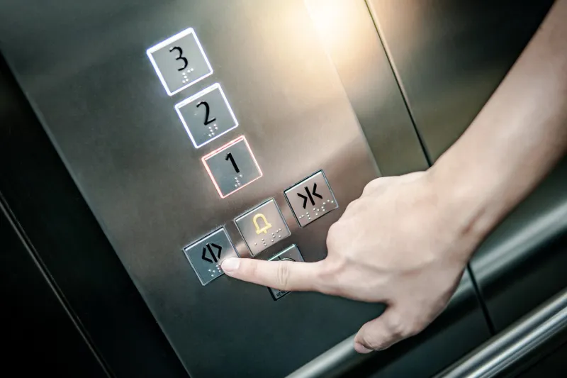 male forefinger pressing on the open door button in elevator (lift) mechanical engineering concept