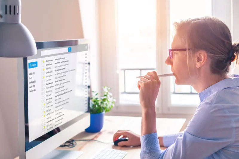 female business person reading email on computer screen at work on internet