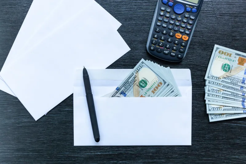 white envelopes with money lie on a black wooden table bribe in an envelope