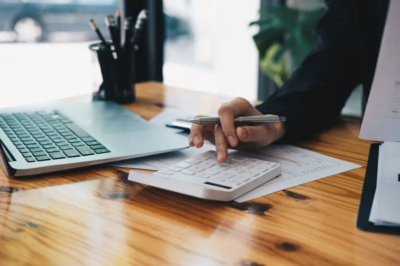 close up an accountant working about financial with calculator at his office to calculate expenses, accounting concept