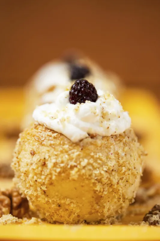 dessert aux pommes avec noix, crème fouettée et mûre