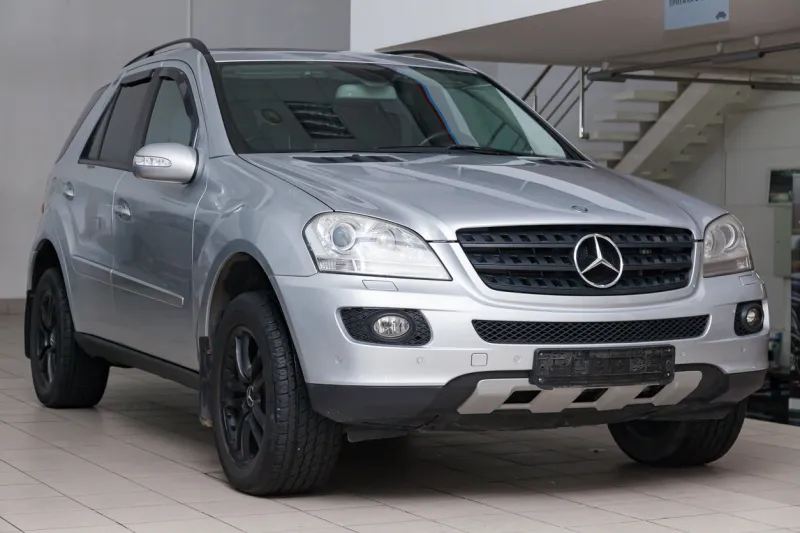 novosibirsk, russia - 08012018  silver mercedes benz ml350 m-class 2007 year front view with dark gray interior in excellent condition in a dealership with white walls
