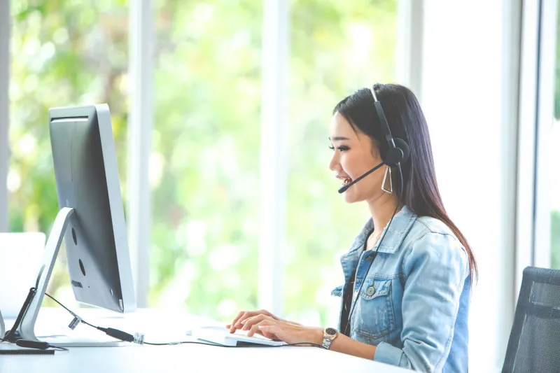 attractive business woman asian in suits and headsets are smiling while working with computer at office customer service assistant working in office